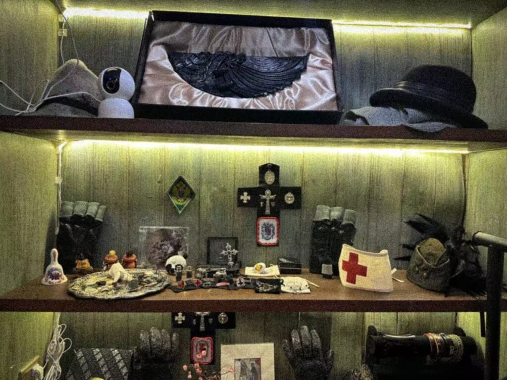 Hats, accessories and archival objects displayed on illuminated shelves.
