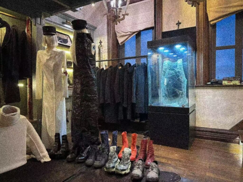 Boots, mannequins and garments arranged beside the display case.