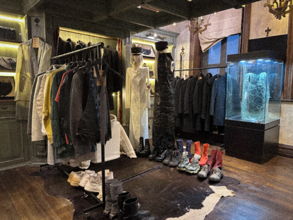 Wide view of the SECTION archive with clothing rails, mannequins, footwear and an illuminated display case.